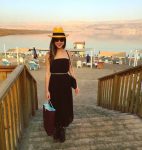 mujer con sombrero y vestido en la playa